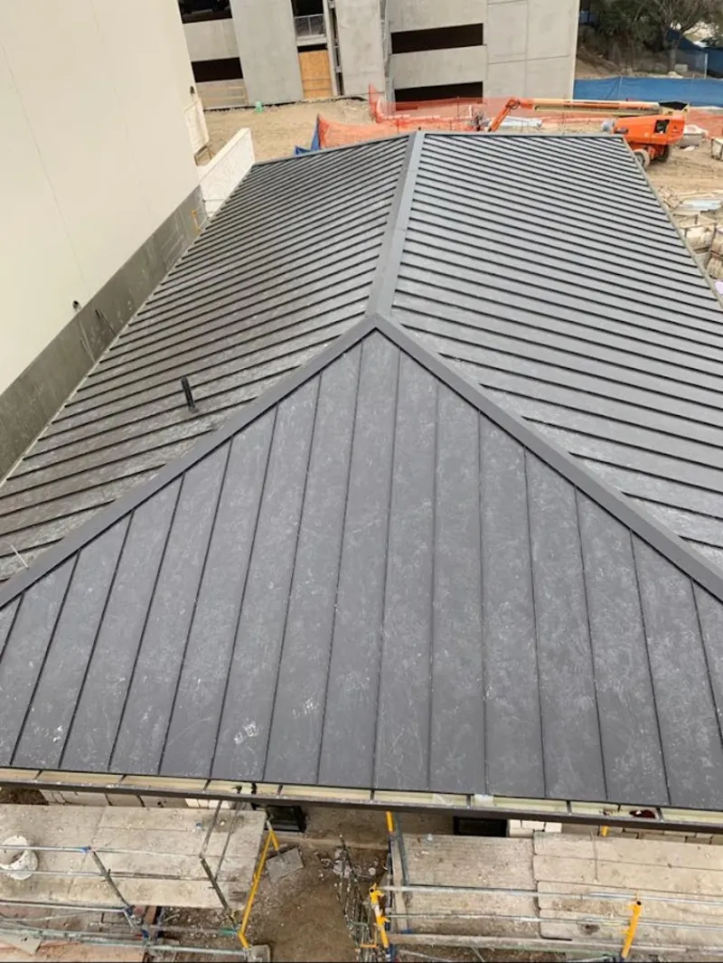 Commercial metal roof construction with crane equipment in Chester